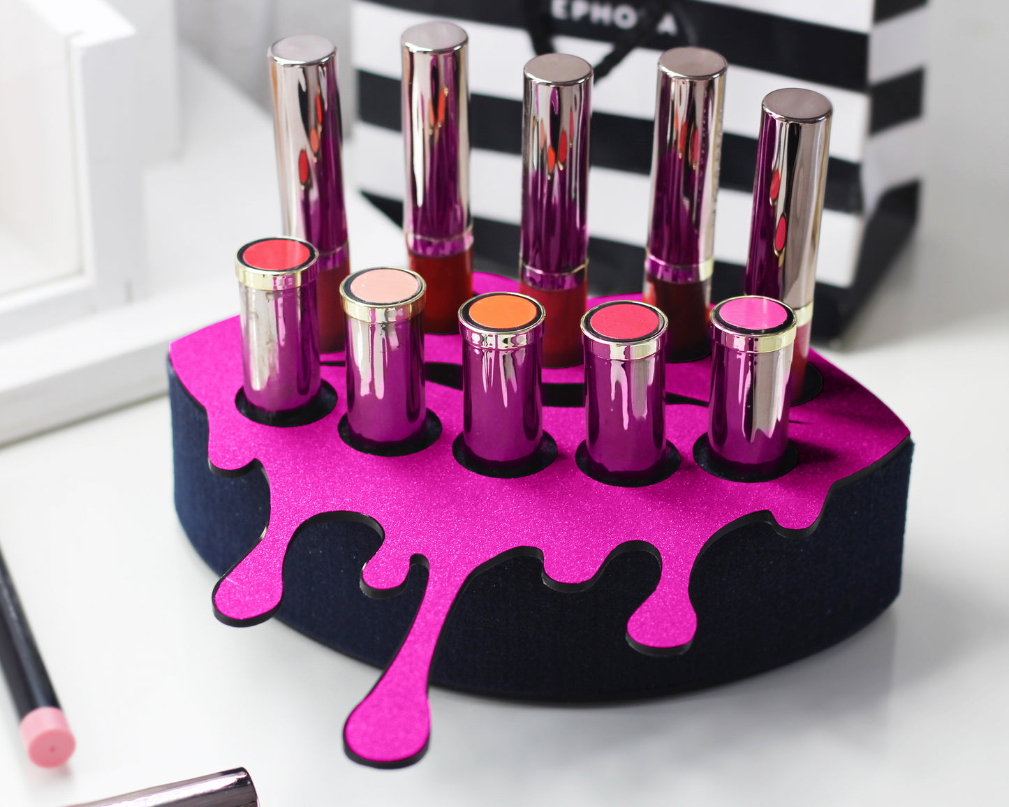 Small Lip Design Lipstick Organizer holding 10 lipsticks mounted on the wall with lipstick easily accessible and organized. Hanging Lipstick Holder that looks like wall art. Shown sitting on a makeup vanity.