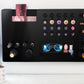 Black Ultra Complete Makeup Solution Organizer shown mounted on the wall holding lipsticks, lip glosses, nail polishes, brushes, sunglasses and more by keeping items accessible and off of the counter. Shown next to a makeup vanity with samples of suggested items the organizer can hold.