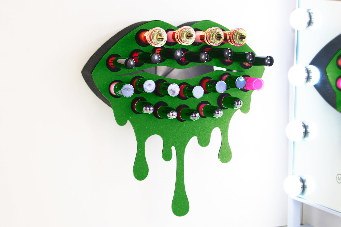 Green Medium Lip Design Lipstick Organizer holding 23 lipsticks mounted on the wall, keeping lipstick organized and easy to reach. This wall mounted makeup organizer looks like art on the wall of your bathroom or makeup room.