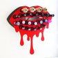 Red Medium Lip Design Lipstick Organizer holding 23 lipsticks mounted on the wall, keeping lipstick organized and easy to reach. This wall mounted makeup organizer looks like art on the wall of your bathroom or makeup room.