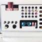 White Ultra Complete Makeup Solution Organizer shown mounted on the wall holding lipsticks, lip glosses, nail polishes, brushes, sunglasses and more by keeping items accessible and off of the counter. Shown next to a makeup vanity with samples of suggested items the organizer can hold.