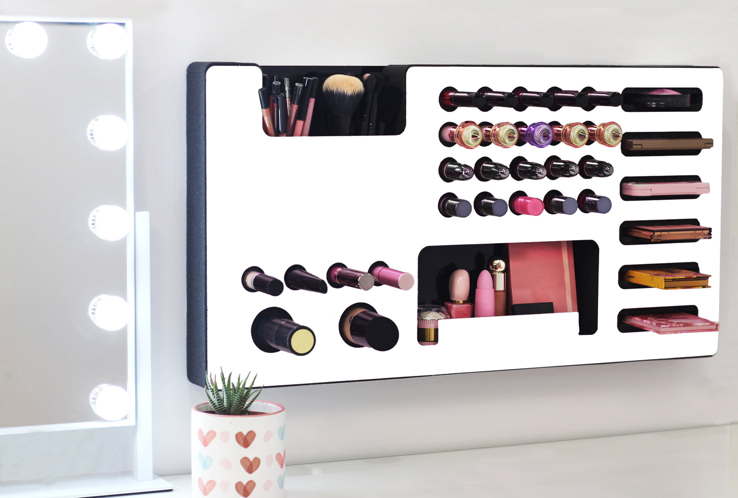White Ultra Complete Makeup Solution Organizer shown mounted on the wall holding lipsticks, lip glosses, nail polishes, brushes, sunglasses and more by keeping items accessible and off of the counter. Shown next to a makeup vanity with samples of suggested items the organizer can hold. Tilted to the right to show the wall mounted makeup organizer at a different angle while still on the wall.
